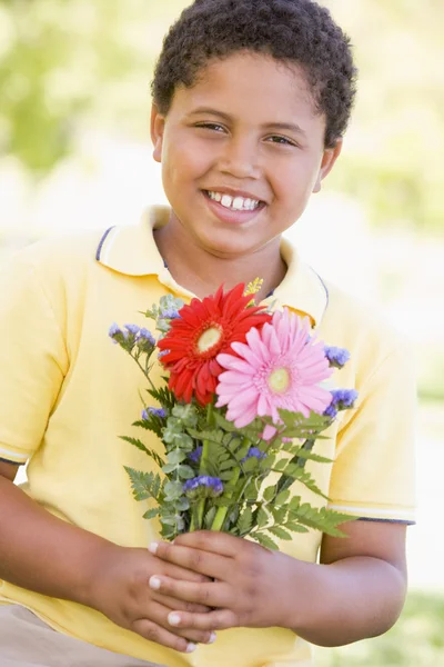Ung Pojke Hålla Blommor Och Leende — Stockfoto