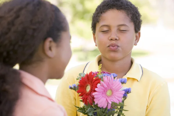 Mladý Chlapec Dává Mladé Dívce Květiny Svraštění — Stock fotografie