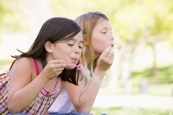 Two Young Girls Blowing Bubbles Outdoors — Stock Photo, Image