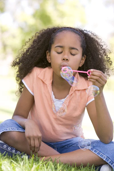 Young girl blowing bubbles outdoors — Stock Photo, Image