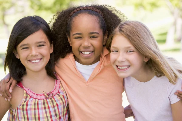 Drie jonge meisje vrienden buitenshuis glimlachen — Stockfoto