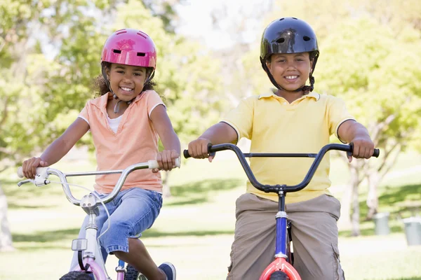 弟と妹屋外で自転車に微笑む — ストック写真
