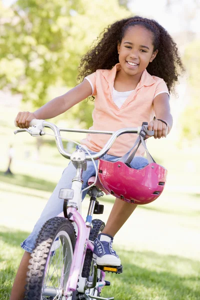Νεαρό κορίτσι με το ποδήλατο που είναι χαμογελώντας σε εξωτερικούς χώρους — Φωτογραφία Αρχείου