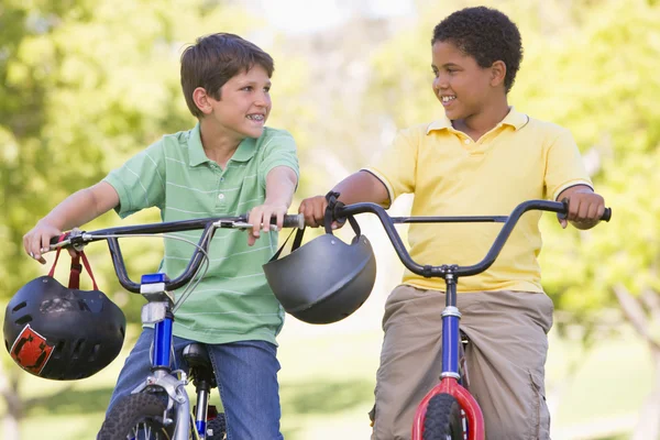 Dwóch młodych chłopców na rowery na zewnątrz uśmiechający się — Zdjęcie stockowe