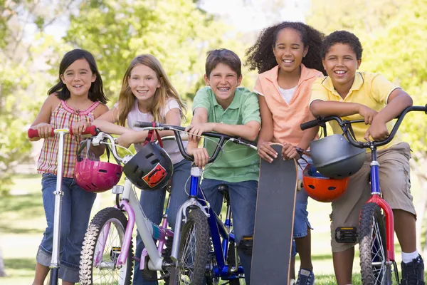 与自行车滑板车和滑板室外五个年轻的朋友 — 图库照片