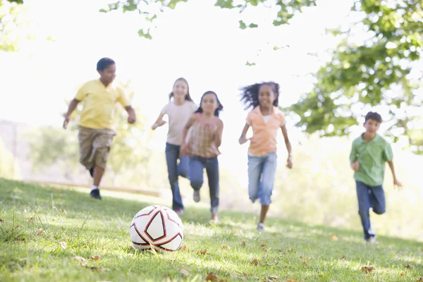 Five young friends playing soccer — Stockfoto