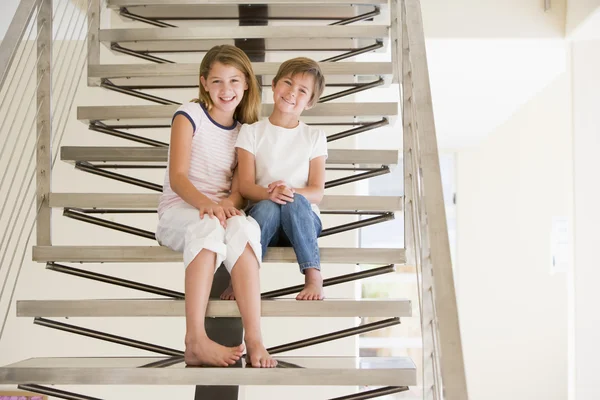 Две молодые девушки сидят дома на лестнице — стоковое фото