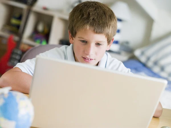 小男孩在他的卧室中使用的笔记本电脑 — 图库照片