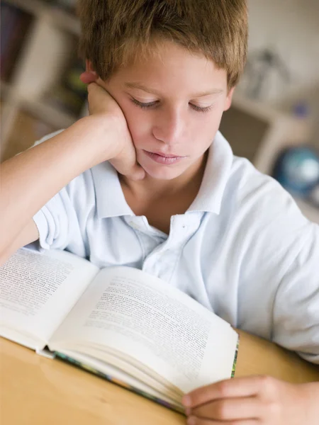 Młody chłopiec czytanie książki w swoim pokoju — Zdjęcie stockowe