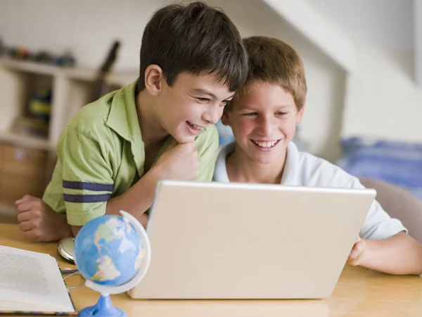 Iki genç çocuklar evde bir dizüstü bilgisayar kullanarak — Stok fotoğraf