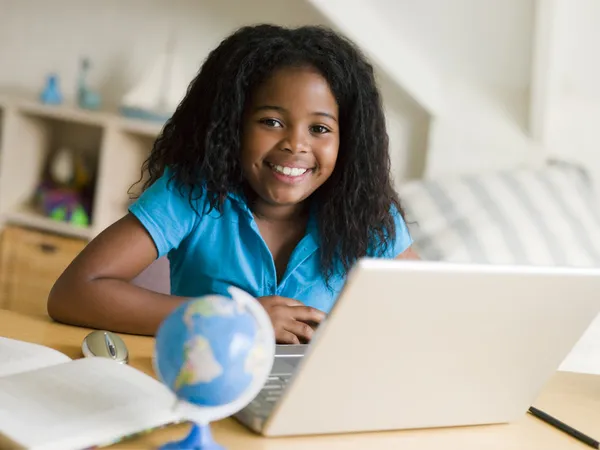 Молода дівчина робить домашнє завдання на ноутбуці — стокове фото