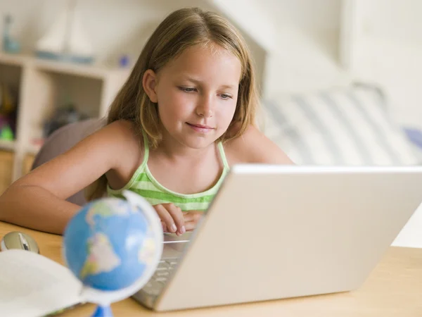Молодая девушка делает домашнюю работу на ноутбуке — стоковое фото