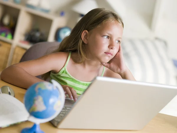 Молодая девушка делает домашнюю работу на ноутбуке — стоковое фото