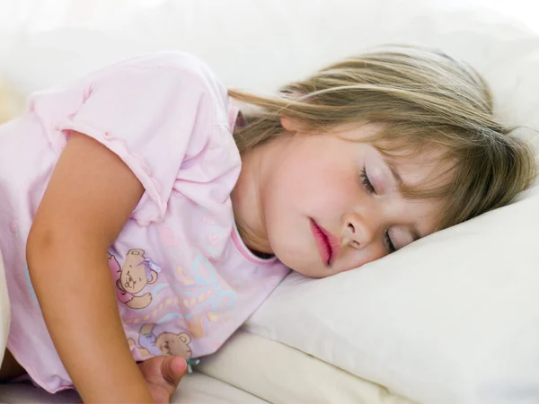 Mladá dívka leží v posteli — Stock fotografie