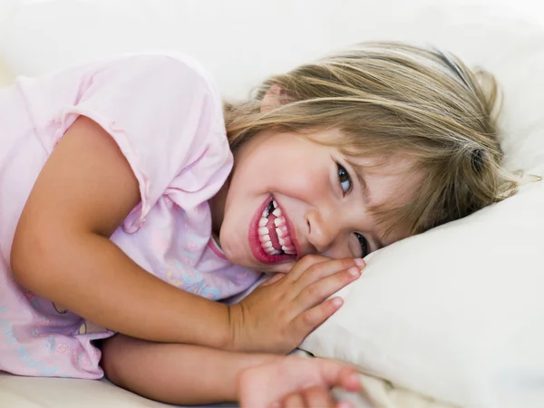 Joven chica acostada en su cama — Foto de Stock