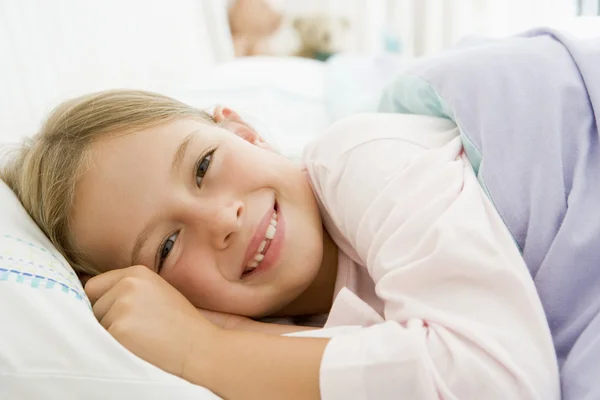 Giovane ragazza sdraiata nel suo letto — Foto Stock