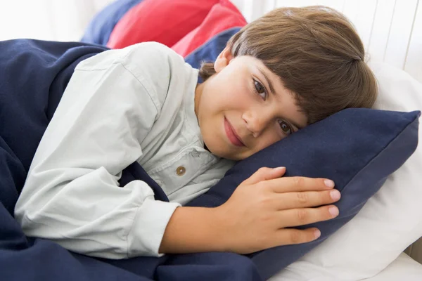 Kleiner Junge legt sich in sein Bett — Stockfoto