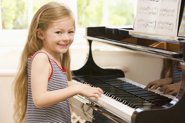 Ung flicka spelar piano — Stockfoto