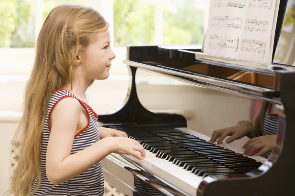 若いです女の子演奏ピアノ — ストック写真
