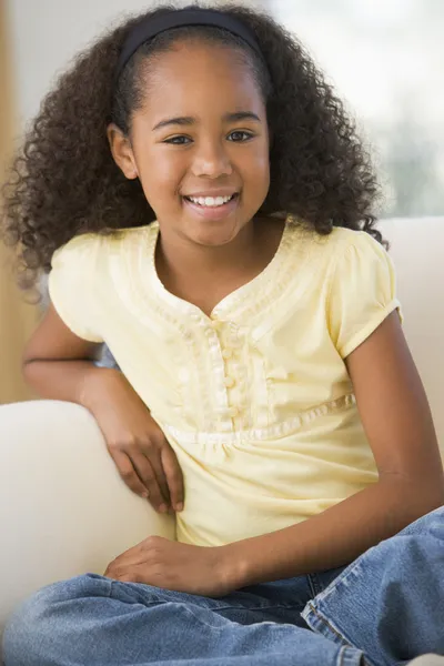 Młoda dziewczyna siedzi na kanapie w domu — Zdjęcie stockowe
