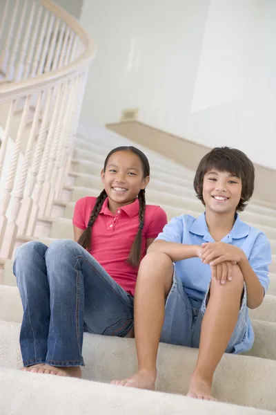兄と妹の家で階段の吹き抜けの上に座って — ストック写真