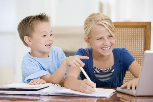 Chłopiec, wskazując na duże siostry zadanie domowe na laptopie — Zdjęcie stockowe