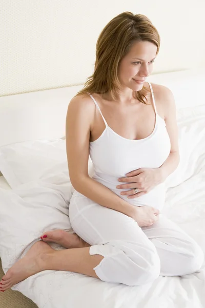 Беременная Женщина Сидит Постели Улыбается — стоковое фото