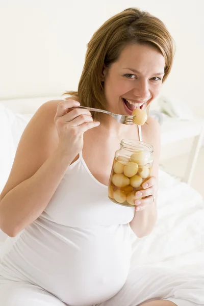 Беременная Женщина Постели Ест Маринованные Яйца Улыбаясь — стоковое фото