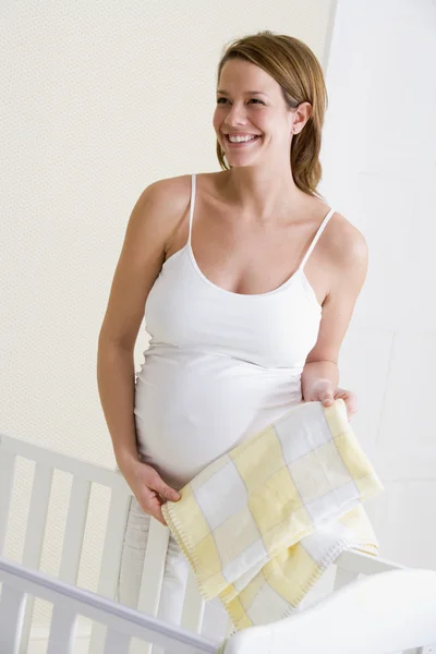 Беременная Женщина Устанавливает Детскую Кроватку Улыбаясь — стоковое фото