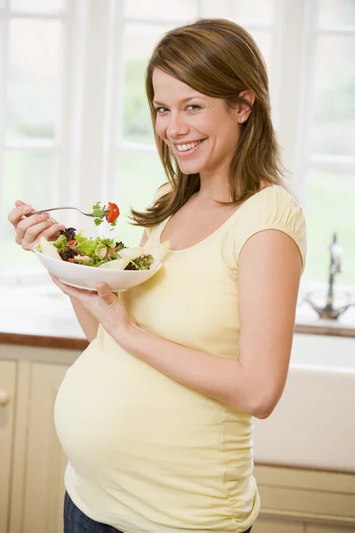 Беременная Женщина Кухне Ест Салат Улыбаясь — стоковое фото