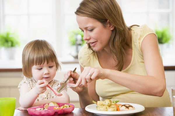 Schwangere Mutter in Küche isst Hühnchen und Gemüse — Stockfoto