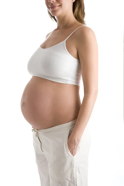 Těhotná žena s úsměvem a břicho vystavena — Stock fotografie