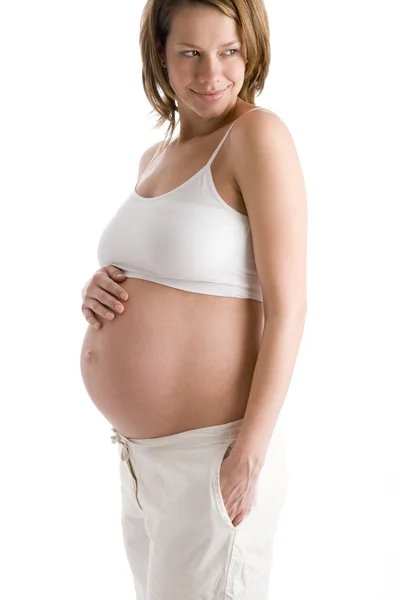 Pregnant woman holding exposed belly smiling — Stock Photo, Image