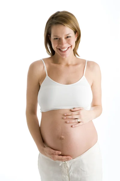 Mulher grávida segurando barriga exposta rindo — Fotografia de Stock