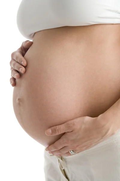 Mujer embarazada sosteniendo vientre expuesto — Foto de Stock