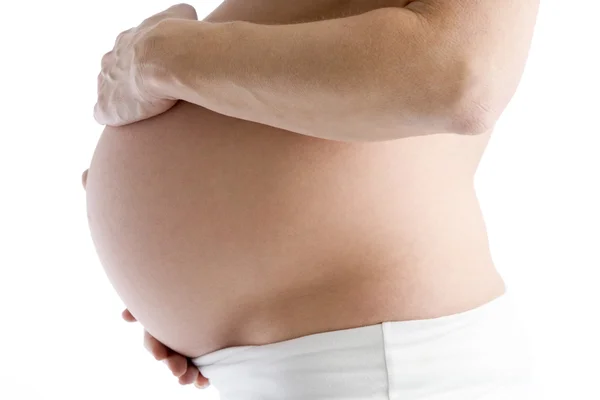 Mulher grávida segurando barriga exposta — Fotografia de Stock