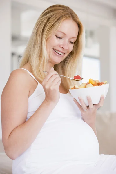 Gravid kvinna med skål frukt sallad leende — Stockfoto