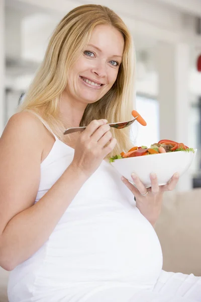 Těhotná žena s miskou salátu s úsměvem — Stock fotografie