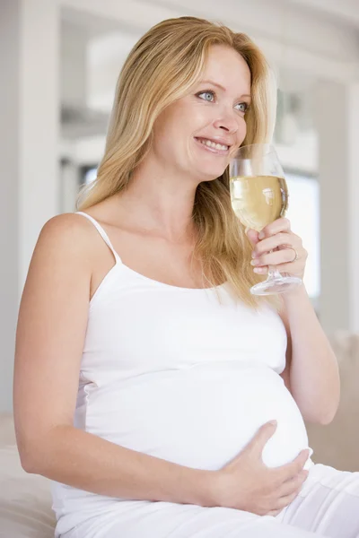 Έγκυος γυναίκα με ποτήρι λευκό κρασί χαμογελώντας — Φωτογραφία Αρχείου