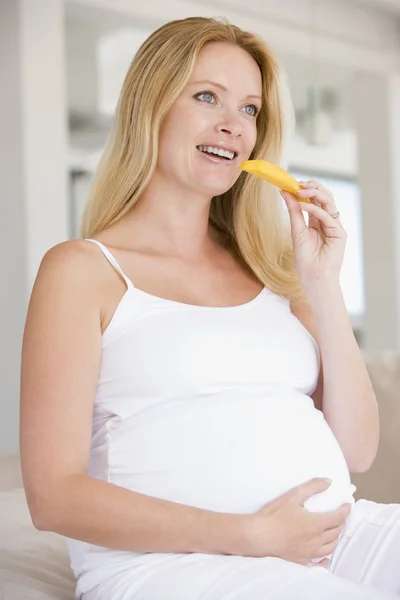 Mujer embarazada comiendo rebanada de melón y sonriendo — Foto de Stock
