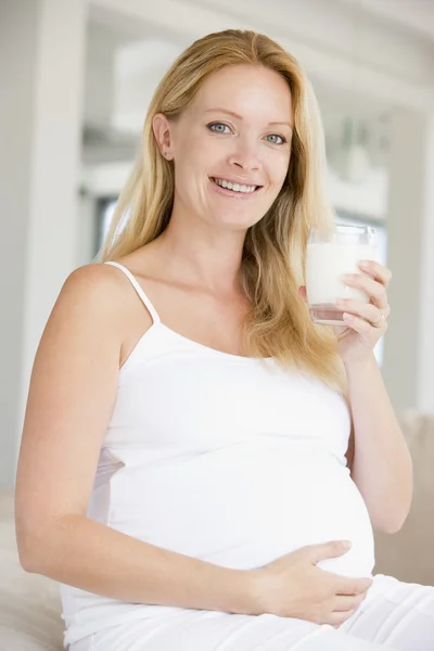 Gravid kvinna med glas mjölk leende — Stockfoto