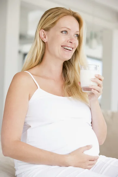 Kobieta w ciąży z szklanką mleka uśmiechający się — Zdjęcie stockowe