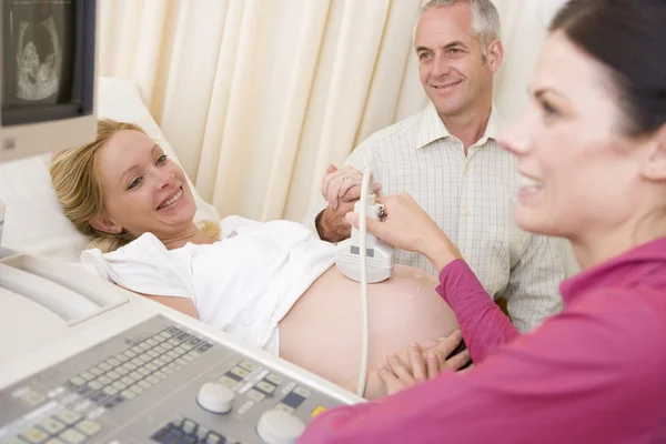 妊娠中の女性の夫の時計を貴方の医師から超音波を取得 — ストック写真