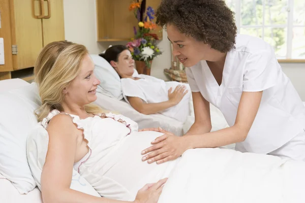 妊婦の腹を確認し 笑顔を看護師します — ストック写真