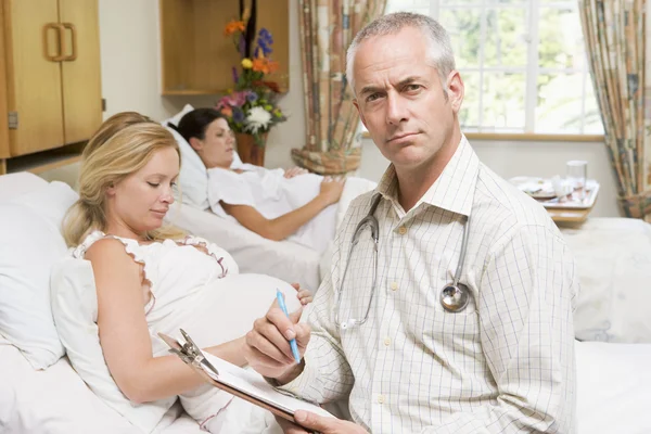 Arzt Sitzt Bei Schwangeren Mit Diagramm — Stockfoto