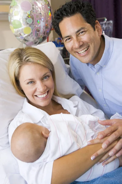 Νέα μητέρα με το μωρό και το σύζυγό της στο νοσοκομείο χαμογελώντας — Φωτογραφία Αρχείου