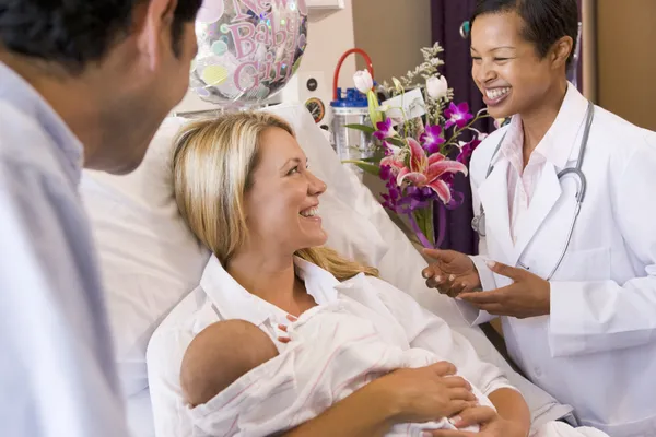 Novos Pais Com Bebê Conversando Com Médico Sorrindo — Fotografia de Stock