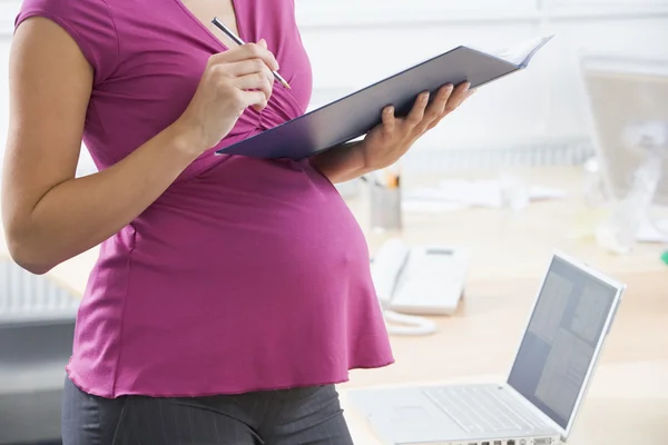 Беременная женщина на работе — стоковое фото
