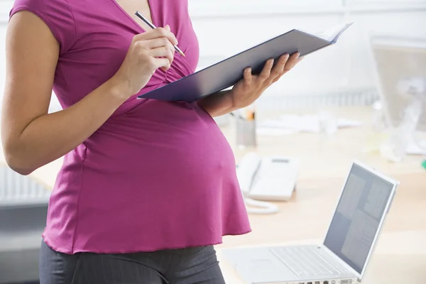 Gravid kvinna på jobbet — Stockfoto