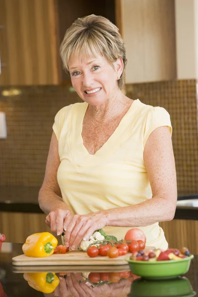 Femme coupant des légumes — Photo